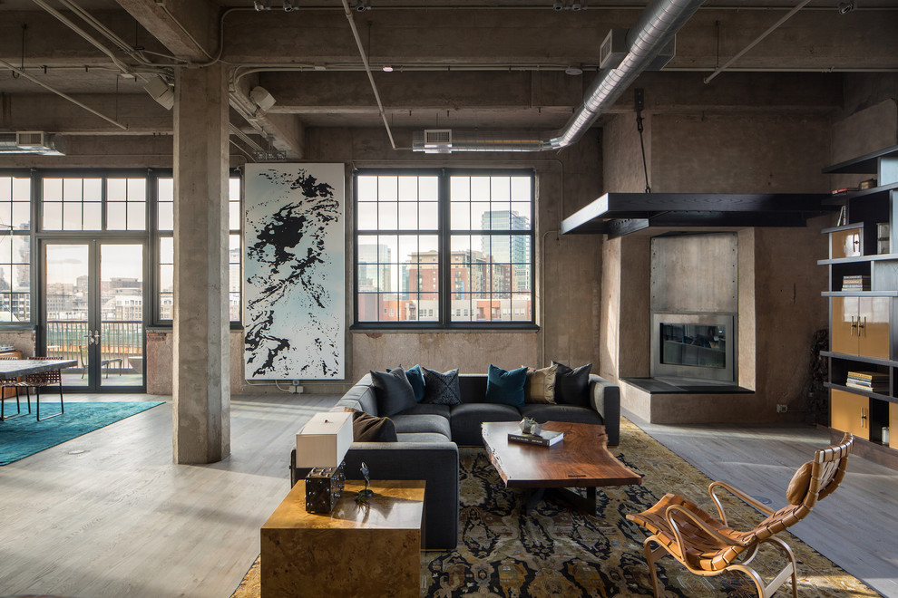 Foto de salón abierto urbano con chimenea de esquina, marco de chimenea de metal, suelo de madera clara y paredes marrones