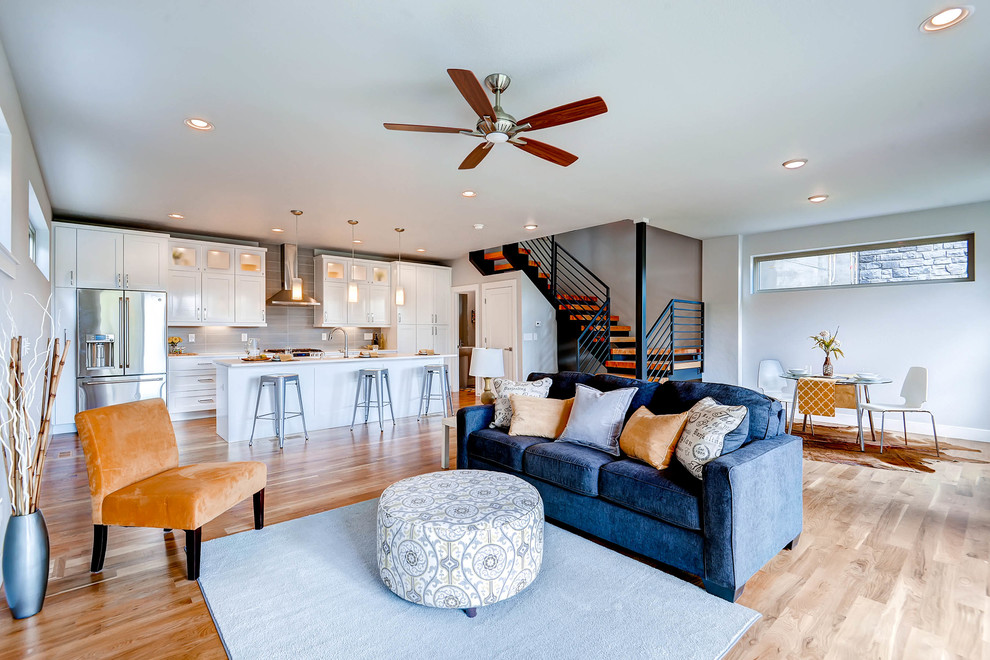 Offenes Klassisches Wohnzimmer ohne Kamin mit weißer Wandfarbe und hellem Holzboden in Denver