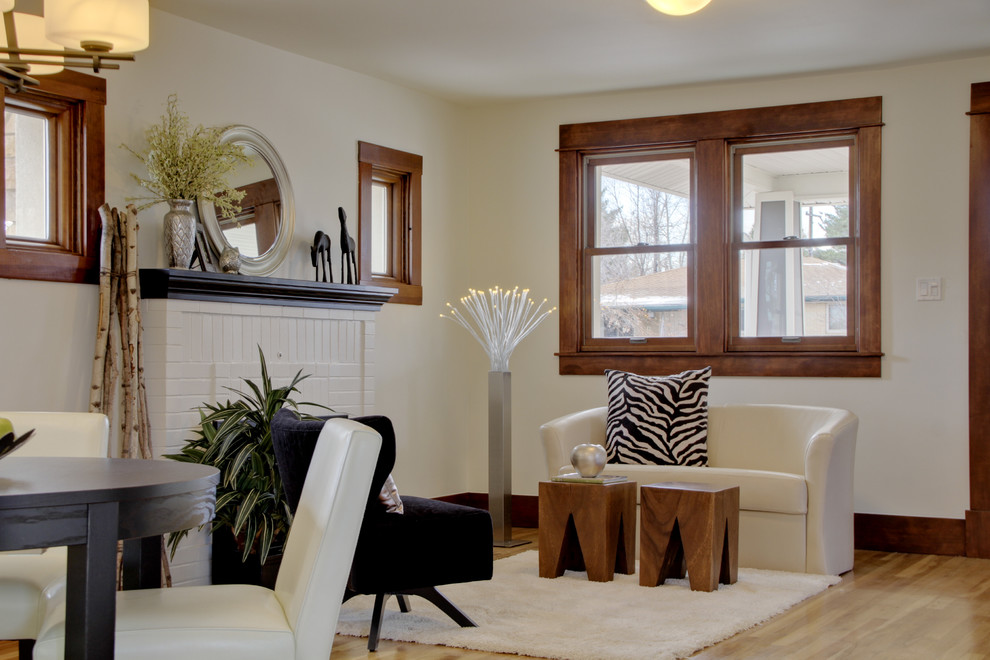 На фото: открытая гостиная комната среднего размера в стиле фьюжн с бежевыми стенами, светлым паркетным полом, стандартным камином, фасадом камина из кирпича и коричневым полом