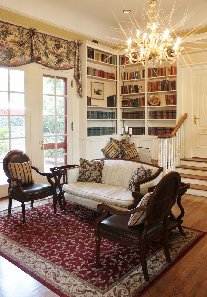 Ispirazione per un soggiorno chic di medie dimensioni e chiuso con libreria, pareti beige e parquet chiaro