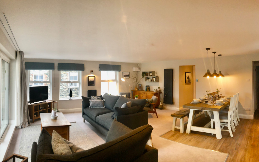 Large scandi open plan living room in Other with a reading nook, grey walls, carpet, a freestanding tv and grey floors.