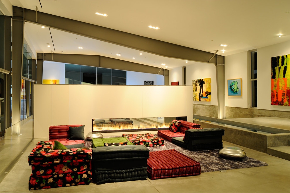 Immagine di un soggiorno minimal con sala formale, pareti bianche, pavimento in cemento, camino bifacciale e nessuna TV