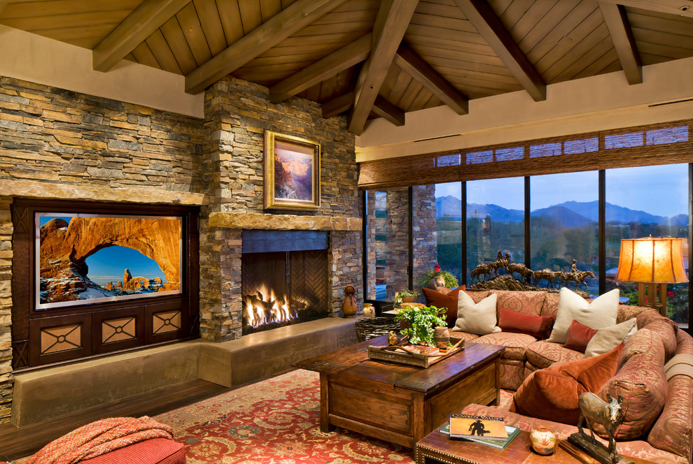 Design ideas for a large contemporary open plan living room in Phoenix with a stone fireplace surround, dark hardwood flooring, a standard fireplace, a built-in media unit, beige walls, brown floors and feature lighting.
