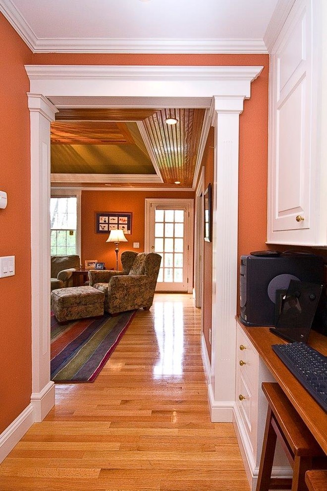 Idee per un soggiorno classico con pareti arancioni e parquet chiaro