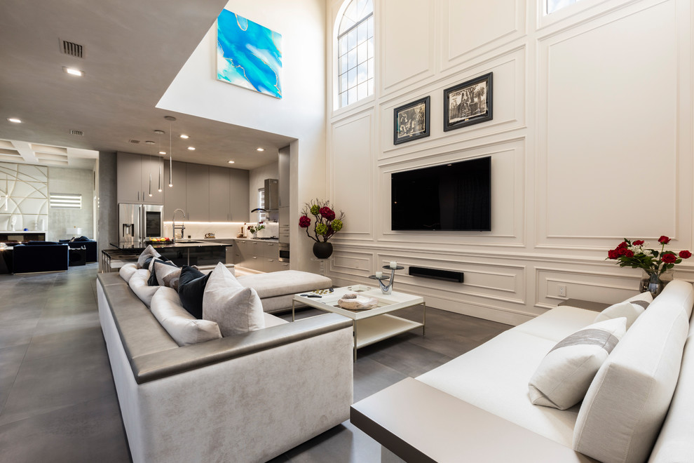 Esempio di un grande soggiorno contemporaneo aperto con sala formale, pareti bianche, pavimento in gres porcellanato, TV a parete e pavimento grigio