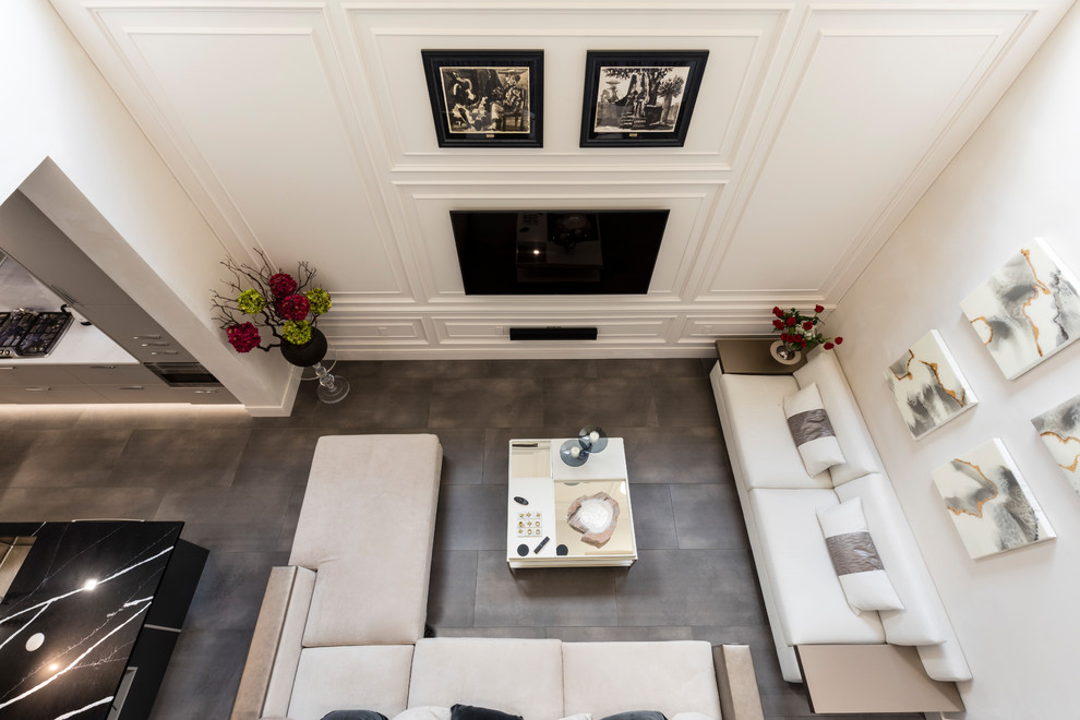 Imagen de salón para visitas abierto, actual, grande, con paredes blancas, suelo de baldosas de porcelana, televisor colgado en la pared y suelo gris