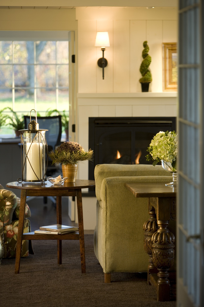 Design ideas for a country living room in Burlington with a wooden fireplace surround and a standard fireplace.