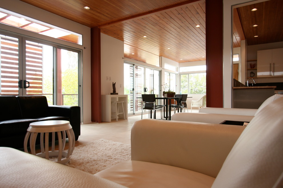 Imagen de salón para visitas abierto contemporáneo grande sin chimenea con paredes beige, suelo de travertino y televisor retractable