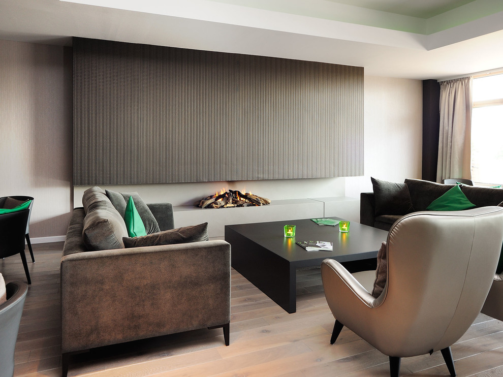 Пример оригинального дизайна: парадная гостиная комната в современном стиле с паркетным полом среднего тона, горизонтальным камином и коричневым диваном без телевизора