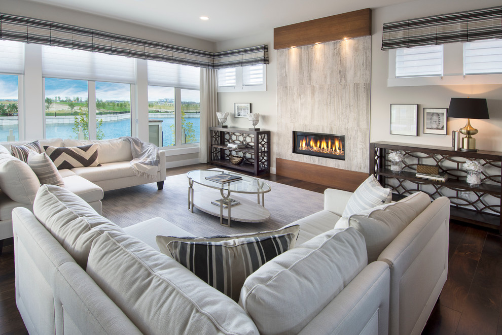This is an example of a large contemporary open plan living room in Calgary with grey walls, dark hardwood flooring, a ribbon fireplace and a tiled fireplace surround.
