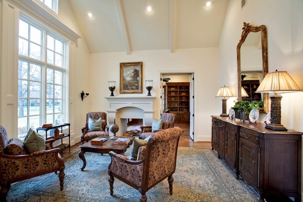 Medium sized classic formal enclosed living room in Dallas with white walls, light hardwood flooring, a two-sided fireplace and a plastered fireplace surround.