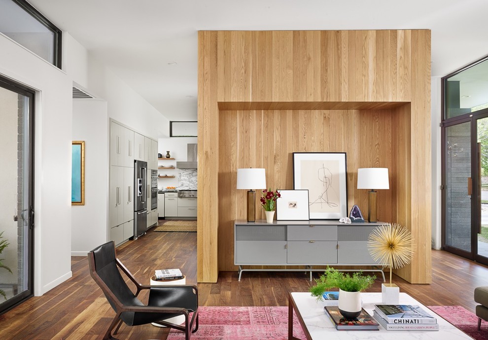 Offenes Retro Wohnzimmer mit weißer Wandfarbe und braunem Holzboden in Austin
