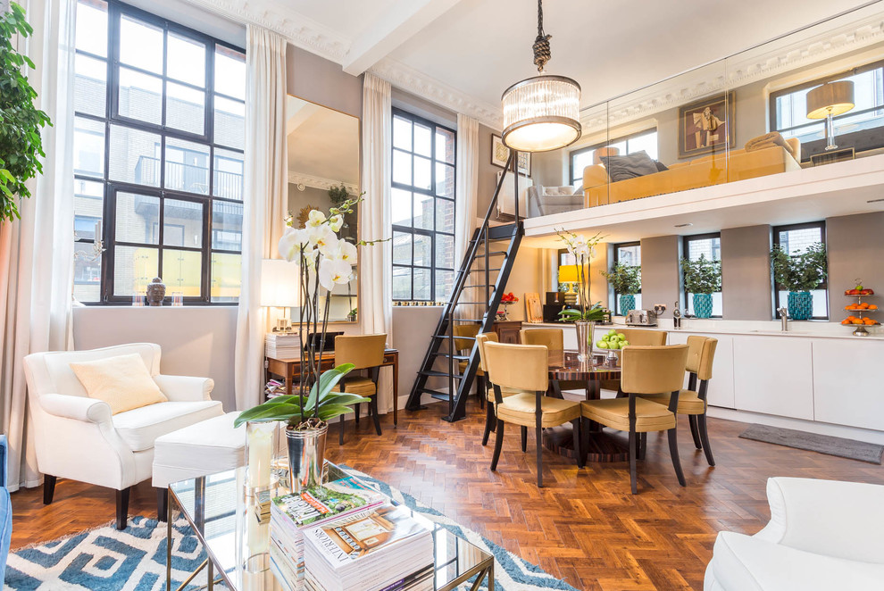 Cette image montre un salon mansardé ou avec mezzanine traditionnel avec un mur gris, un sol en bois brun et un sol marron.
