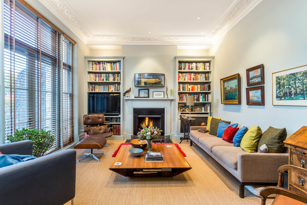 Design ideas for a medium sized traditional enclosed living room in London with blue walls, carpet, a standard fireplace, a built-in media unit and brown floors.