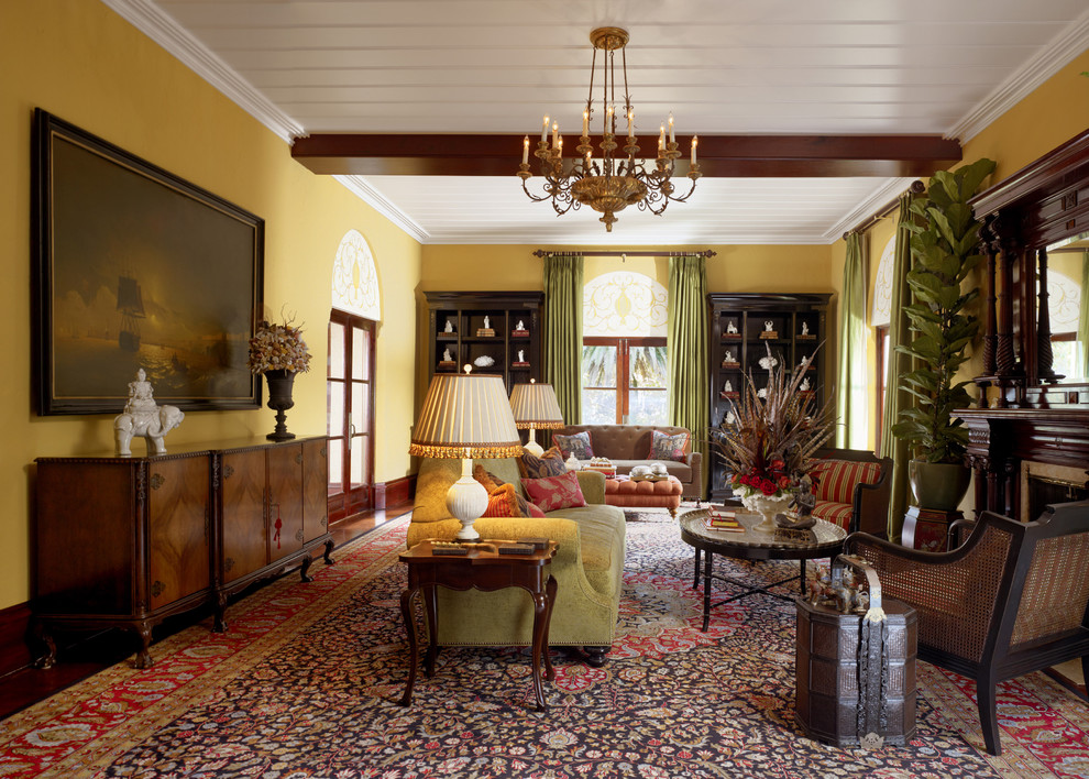 Idée de décoration pour un très grand salon tradition avec un mur jaune et une cheminée standard.