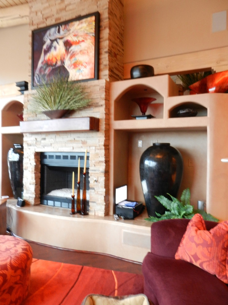 Idée de décoration pour un salon bohème de taille moyenne avec un mur marron, parquet foncé, une cheminée standard, un manteau de cheminée en pierre et un sol marron.