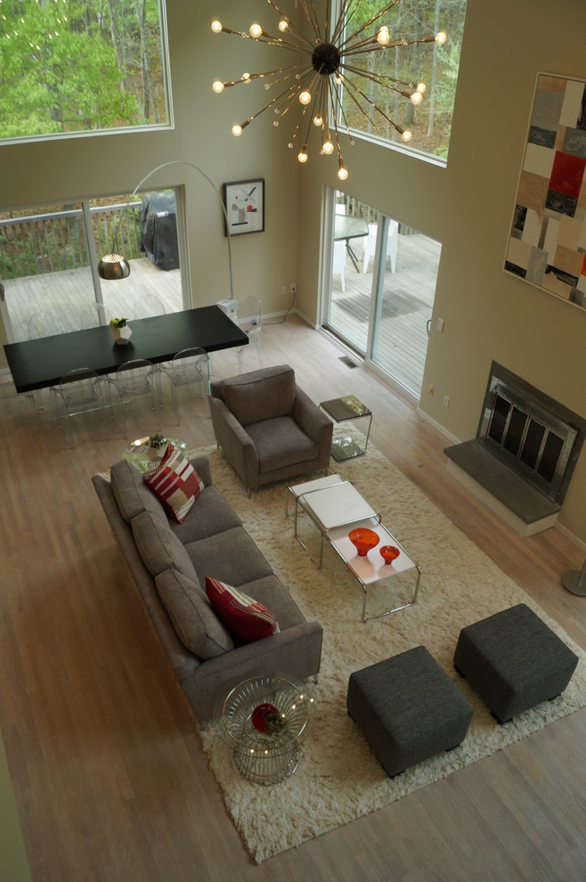 Idee per un grande soggiorno design aperto con pareti grigie, parquet chiaro e camino classico