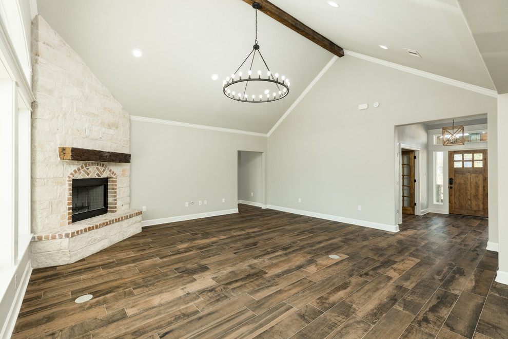 Inspiration for a large farmhouse open plan living room in Houston with beige walls, ceramic flooring, a corner fireplace, a stone fireplace surround and brown floors.
