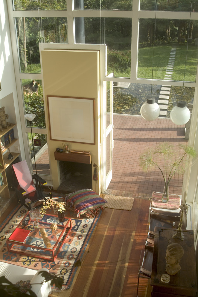 На фото: гостиная комната в стиле фьюжн с с книжными шкафами и полками и паркетным полом среднего тона с