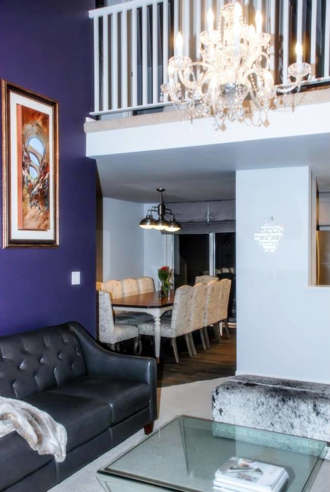 デンバーにある高級な中くらいなトランジショナルスタイルのおしゃれなリビングロフト (紫の壁、カーペット敷き、暖炉なし、石材の暖炉まわり、壁掛け型テレビ) の写真