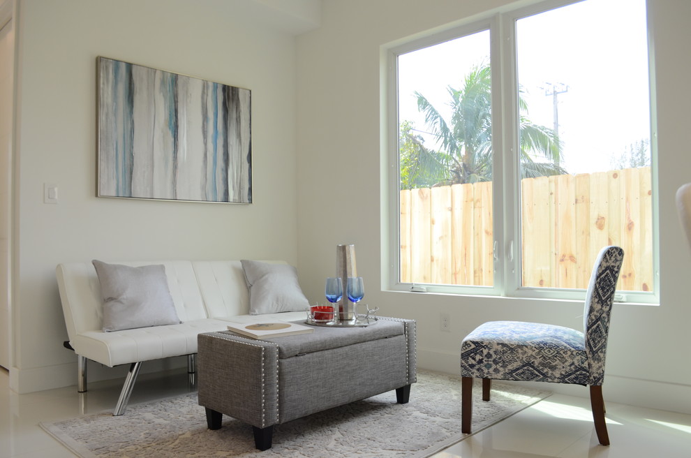 Immagine di un soggiorno minimalista di medie dimensioni e chiuso con pareti bianche, pavimento in gres porcellanato, nessun camino, nessuna TV e pavimento beige