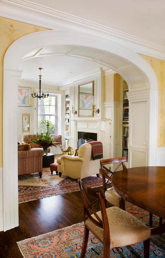 Imagen de salón para visitas abierto tradicional grande con paredes amarillas, suelo de madera oscura, todas las chimeneas y marco de chimenea de madera