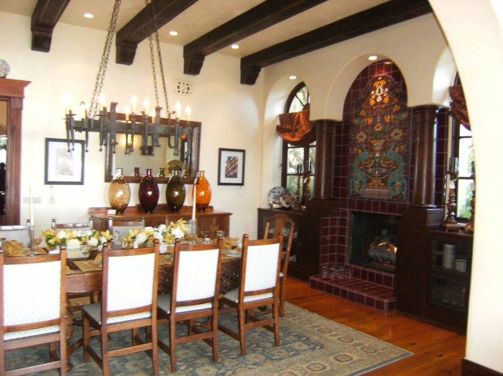 This is an example of a contemporary living room in Los Angeles with beige walls, medium hardwood flooring, a standard fireplace, a tiled fireplace surround and no tv.