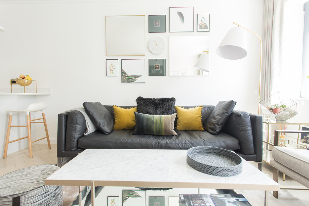 Foto på ett minimalistiskt vardagsrum, med vita väggar, ljust trägolv och beiget golv