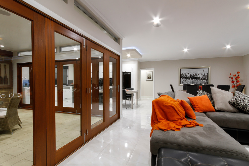 Großes, Offenes Modernes Wohnzimmer mit weißer Wandfarbe, Keramikboden und Multimediawand in Sonstige