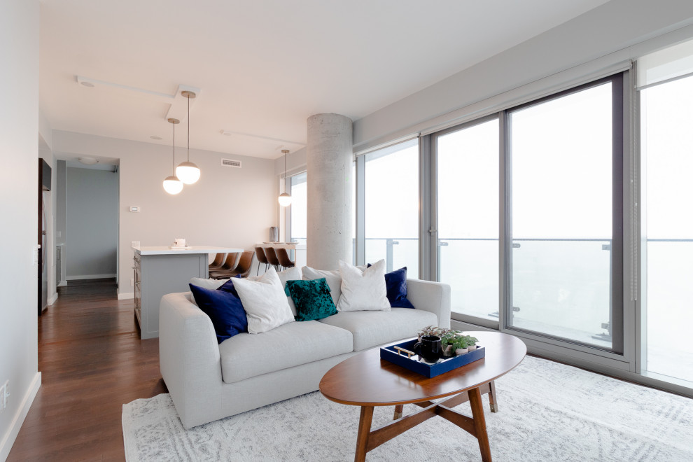 Пример оригинального дизайна: открытая гостиная комната среднего размера в стиле неоклассика (современная классика) с серыми стенами, паркетным полом среднего тона и коричневым полом