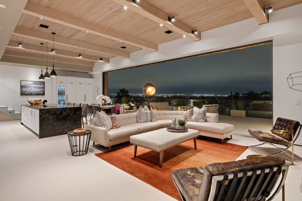 Cette image montre un salon design ouvert avec un mur blanc, un sol gris, poutres apparentes et un plafond en bois.