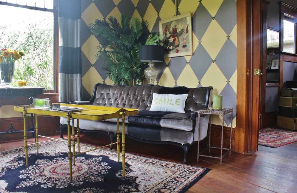 Cette image montre un salon bohème de taille moyenne et fermé avec un mur multicolore, un sol en bois brun, une cheminée standard et aucun téléviseur.