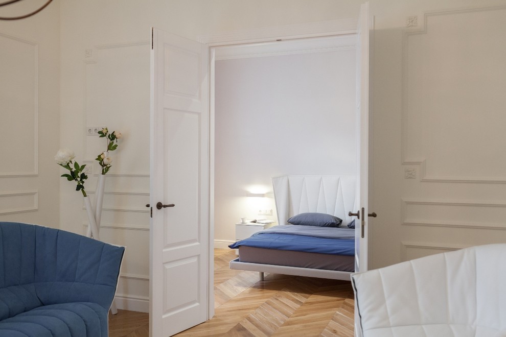 На фото: открытая гостиная комната среднего размера с белыми стенами, паркетным полом среднего тона и телевизором на стене с