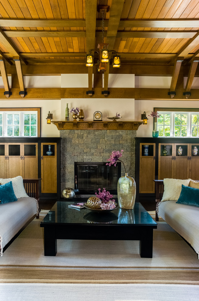 Cette image montre un salon craftsman de taille moyenne et ouvert avec un mur beige, une cheminée standard, un manteau de cheminée en pierre et une salle de réception.