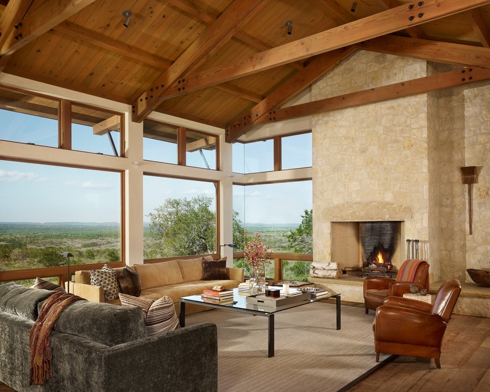 Example of a mid-sized formal and open concept medium tone wood floor living room design in Austin with multicolored walls, a standard fireplace, a stone fireplace and a media wall