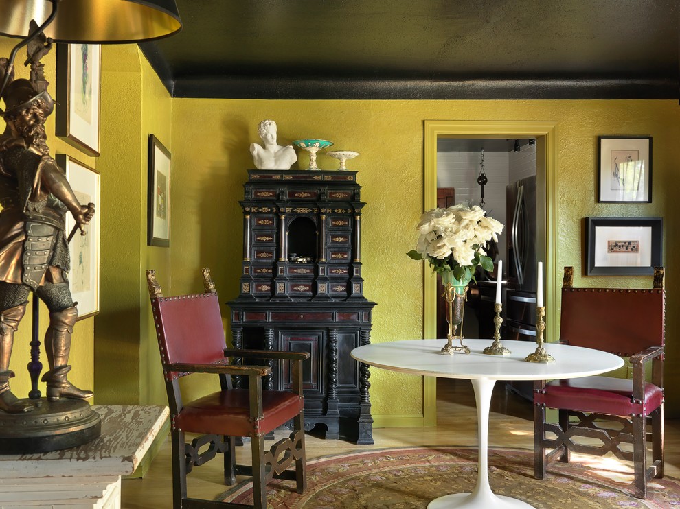 Modelo de salón bohemio con paredes verdes, suelo de madera clara y suelo beige