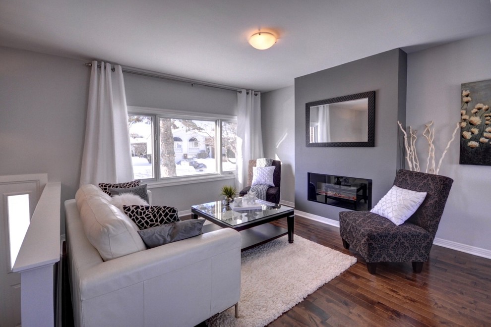 Kleines, Offenes Modernes Wohnzimmer mit grauer Wandfarbe, dunklem Holzboden, Kamin und TV-Wand in Montreal