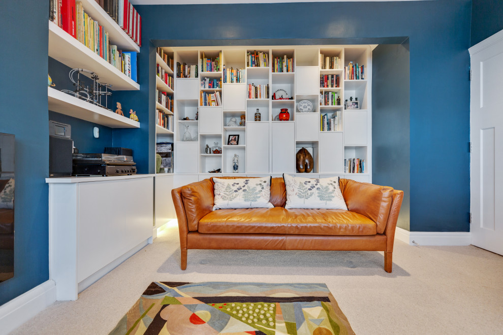Foto de biblioteca en casa cerrada contemporánea de tamaño medio con paredes azules, moqueta, chimeneas suspendidas, televisor colgado en la pared y suelo gris
