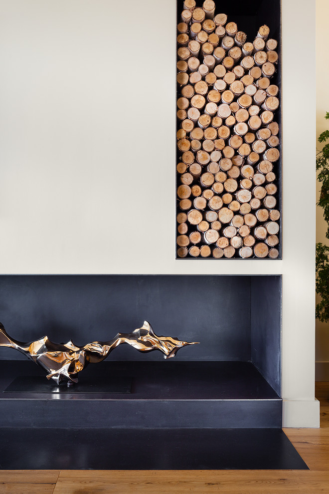 Diseño de salón para visitas abierto actual sin televisor con paredes beige, suelo de madera en tonos medios, estufa de leña y marco de chimenea de metal