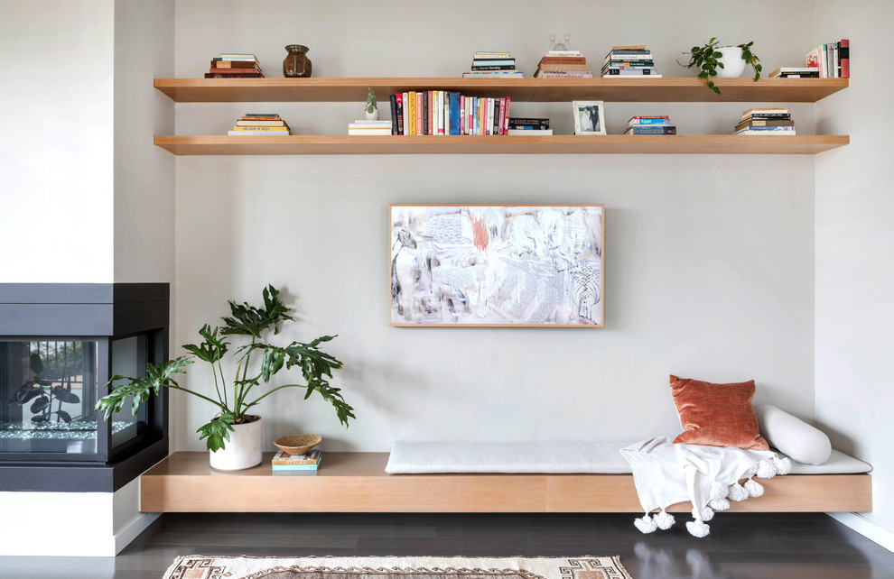 Idéer för ett stort minimalistiskt allrum med öppen planlösning, med grå väggar, mörkt trägolv, en öppen hörnspis, en spiselkrans i metall och brunt golv