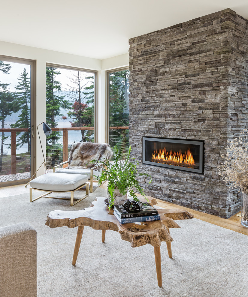 Cette photo montre un salon tendance ouvert avec un mur blanc, un sol en bois brun, une cheminée ribbon et un manteau de cheminée en pierre.