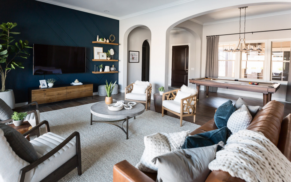 Immagine di un soggiorno eclettico di medie dimensioni e aperto con pareti blu, TV a parete e pavimento marrone