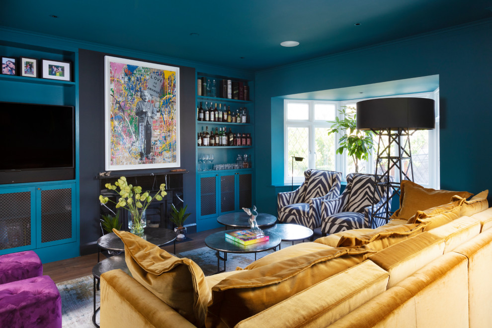 ロンドンにあるエクレクティックスタイルのおしゃれなリビング (青い壁、濃色無垢フローリング、標準型暖炉、タイルの暖炉まわり、壁掛け型テレビ、茶色い床) の写真
