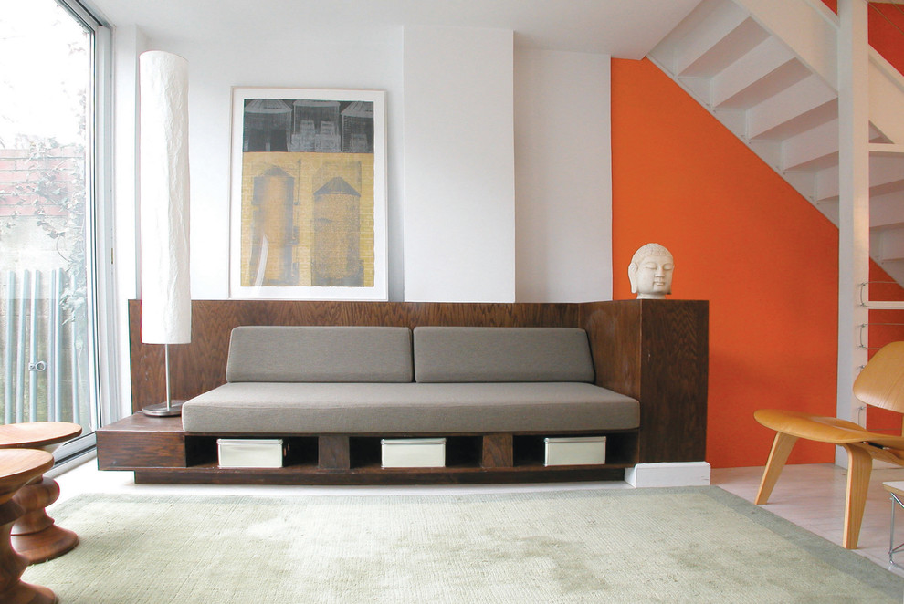 Ispirazione per un soggiorno moderno aperto con pareti arancioni e parquet chiaro