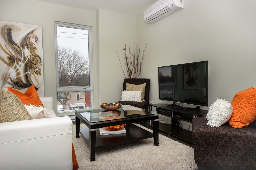 Modern inredning av ett litet allrum med öppen planlösning, med vita väggar och en fristående TV