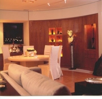 Diseño de salón cerrado actual de tamaño medio con paredes beige, suelo de mármol y televisor colgado en la pared