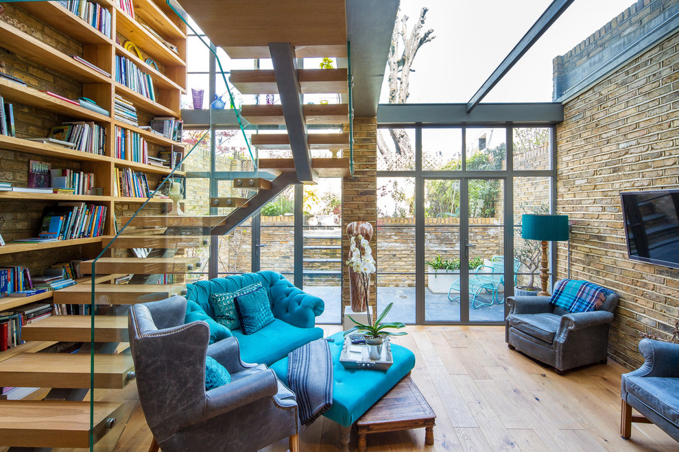 Идея дизайна: парадная, изолированная гостиная комната среднего размера в стиле фьюжн с паркетным полом среднего тона, телевизором на стене и синим диваном