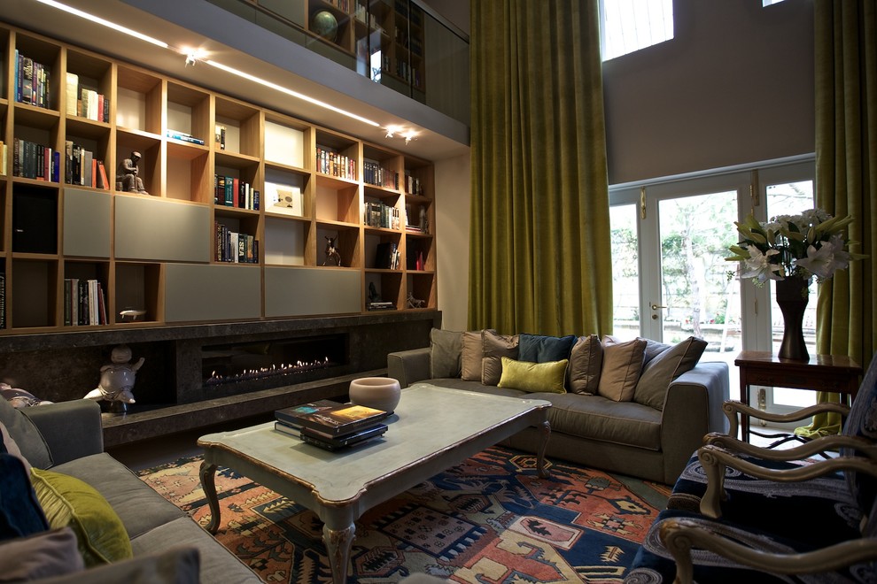 Modelo de biblioteca en casa tipo loft contemporánea grande sin televisor con paredes grises, chimenea lineal y marco de chimenea de piedra