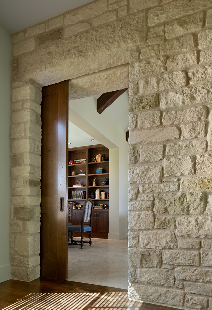 Aménagement d'un salon classique ouvert avec un sol en travertin, un manteau de cheminée en pierre et un sol beige.