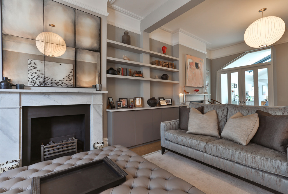 Photo of a medium sized modern formal enclosed living room in London with grey walls, light hardwood flooring, a standard fireplace, a stone fireplace surround and a freestanding tv.